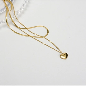 Close-up of golden double-layer necklace with snake chain and Love You heart pendant