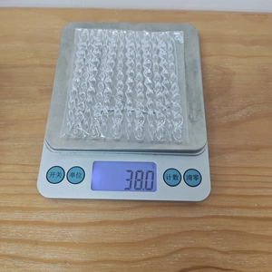 Detailed view of clear acrylic icicle ornaments on a scale showing 38.0 grams weight