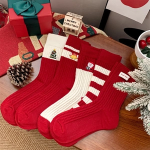 Coffret de chaussettes de Noël rouges et blanches festives sur un support en bois