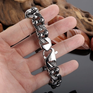 Macro detail of gothic skull engraved links and lobster clasp on silver steel bracelet