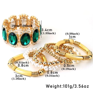 Macro shot of vintage style gold bracelet set with emerald gemstones and pearl beads