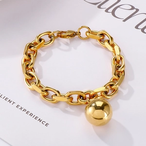 Detailed view of a gold chunky chain bracelet with a polished hollow steel sphere charm