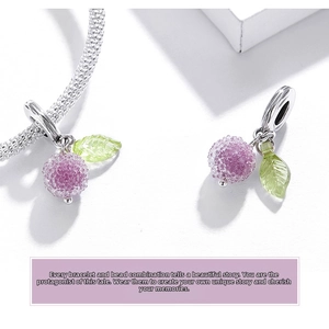 Macro view of a purple textured fruit charm with a green leaf on an S925 silver bracelet