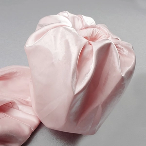 Detailed view of the smooth pink satin fabric and elasticated cuff of the garment