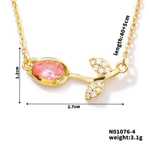 Detail view of gold tulip pendant with pink pear-shaped stone and zircon leaf accents