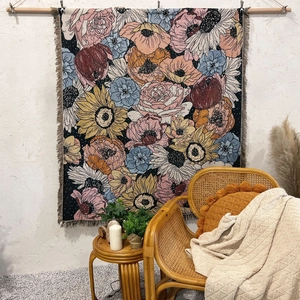 Detailed close-up of bohemian floral woven blanket with intricate fringe trim