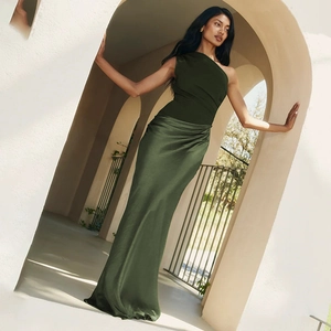 Détail d'une élégante robe longue en satin vert foncé à une épaule avec coupe ajustée