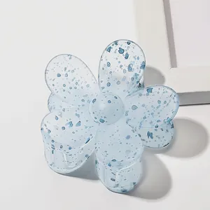 Detail of light blue flower hair claw clip with dark blue spots and metal spring