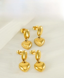 Vista macro di orecchini a cuore placcati in oro 18K con finiture lisce e testurizzate