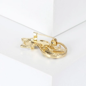 Macro detail showing the golden back structure and secure pin clasp of the cat brooch