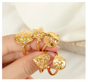 Detail of gold-plated titanium steel rings with embossed patterns and small diamonds