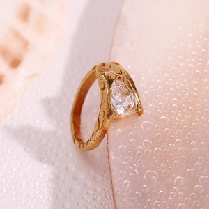 Macro shot of a hammered 18K gold-plated wing ring with a sparkling clear pear-cut stone