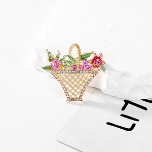 Close-up of golden flower basket brooch with crystal rhinestones and enamel petals