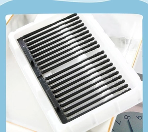 Close-up of black disposable sticky ear swabs organized in a white plastic tray