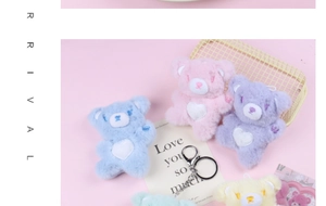 Close-up of five colorful plush bears with heart patches and metal keychains