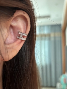 Macro shot of silver H-shaped ear cuff with pave zircon crystals on ear