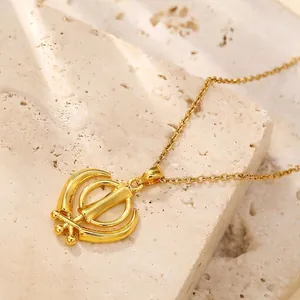 Elegant gold plated Khanda symbol pendant necklace with zirconia on stone background