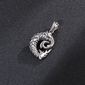 Detailed view of a silver stainless steel dragon pendant with scale textures and fire tail