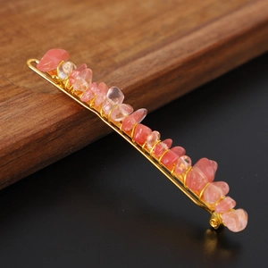 Detailed shot of handmade pink crystal stones wrapped with gold wire on a hairpin