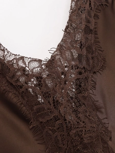 Close-up of chocolate brown satin dress with delicate eyelash lace trim and silk texture