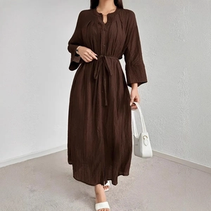 Detailed view of dark brown maxi dress featuring pleated texture and matching waist tie