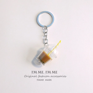 Macro shot of miniature bubble tea keychain with brown liquid, pearls and silver ring