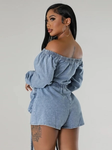 Washed blue denim off-shoulder romper with elastic waist shown from a side back view