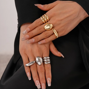 Close-up of minimalist gold and silver oval rings stacked on model's hand