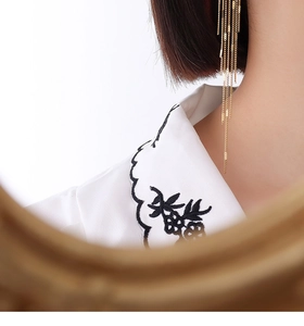 Detail of elegant gold long tassel earrings with multi-layered delicate metal chains