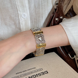 Close-up of vintage mixed-metal stretch bracelet with Love and Hope engraved charms