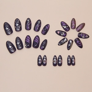 Detail view of dark purple almond press-on nails with glitter stars and moon rhinestones