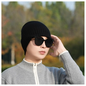 Detailed close-up of a black ribbed knit beanie featuring premium warm fabric texture