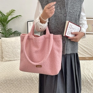 Dettaglio della borsa tote in pile rosa con etichetta in pelle e doppi spallacci
