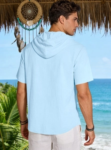 Rear view of light blue linen hooded shirt for men in a tropical beach setting