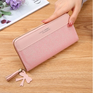 Detail of pink zip-around wallet with glitter stitching and heart tassel charm