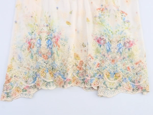 Detail der Blumenstickerei und des Lochspitzensaums an einem beigen französischen Kleid