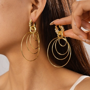 Close-up of gold layered hoop earrings with diamond accents on a model showing fine detail