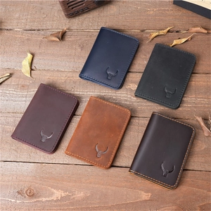 Top view of five crazy horse leather card holders in various colors on wooden desk