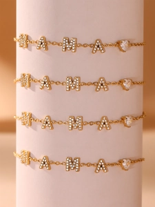 Détail de quatre bracelets dorés MAMA avec zircons en forme de cœur sur un présentoir