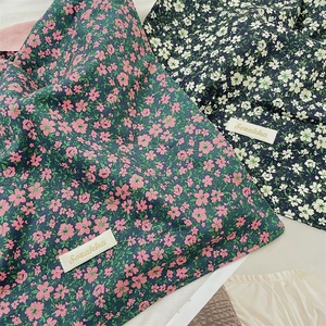 Close-up of floral canvas fabric detail and woven brand label on shoulder bags