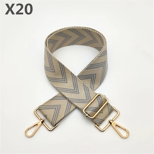 Close-up of wide woven bag strap with blue and white chevron pattern and gold metal hooks