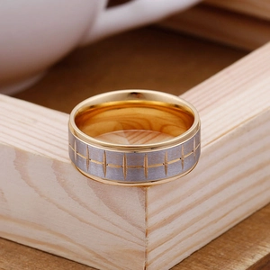 Detailed view of dual-tone gold and silver tire tread ring on a light wood frame