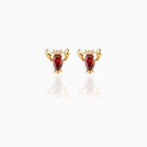 Macro detail of gold lobster stud earrings with red crystal gems and mirrored reflection