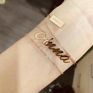 Gros plan détaillé du collier personnalisé au prénom Anna en or rose sur un poignet