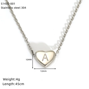 Macro shot of silver stainless steel heart pendant with engraved letter A and size info