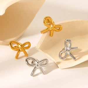 Elegant 18k gold and silver stainless steel bow knot stud earrings on white podium