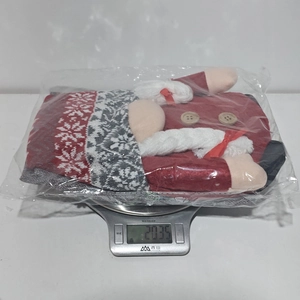 Detailed view of weighted 3D Christmas gnome chair cover in clear protective packaging