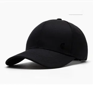 Detail view of cotton baseball cap with a circular metal logo on a black textured fabric