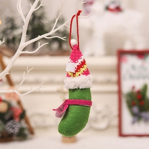 Creative knitted green pickle Christmas ornament with hat and scarf hanging on a tree