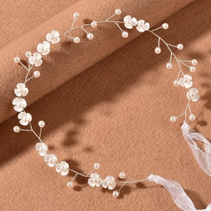 Detailed view of bridal headband with white flowers, pearls, and silver wire on brown felt